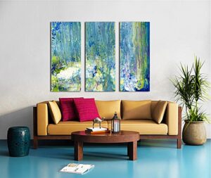 A living room setting with a three canvas panel split print on the wall, featuring a relaxing abstract painting in shades of blue, green, white and gold.